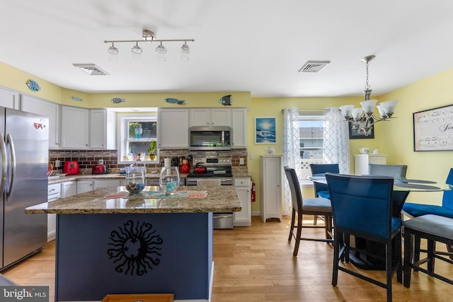 25 N 12th St, Del Haven, NJ 08251 - kitchen featuring appliances with stainless steel finishes, a chandelier, plenty of natural light, and backsplash