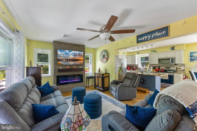 25 N 12th St, Del Haven, NJ 08251 - living area featuring light wood-style flooring, a ceiling fan, and a large fireplace