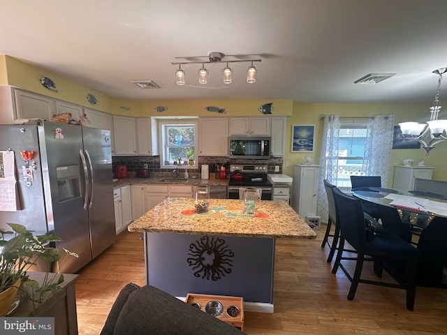 25 N 12th St, Del Haven, NJ 08251 - kitchen featuring stainless steel appliances, a sink, backsplash, white cabinets, and light wood finished floors