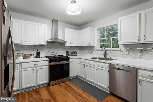 6 E Saxony Dr, New Castle, DE 19720 - kitchen with appliances with stainless steel finishes, wall chimney exhaust hood, a sink, light countertops, and white cabinets