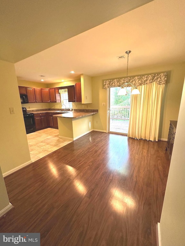 413 Park View Dr, Harrisburg, PA 17110 - kitchen with black appliances, wood finished floors, healthy amount of natural light, a peninsula, and recessed lighting