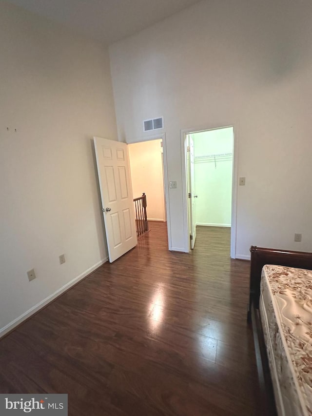 413 Park View Dr, Harrisburg, PA 17110 - unfurnished bedroom featuring dark wood finished floors, a high ceiling, baseboards, and a walk in closet