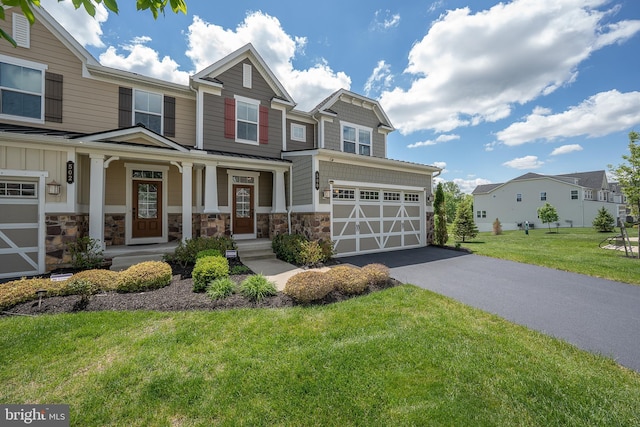 500 Quarry Point Rd, Malvern, PA 19355 - view of front of house with driveway, stone siding, a porch, a front yard, and an attached garage