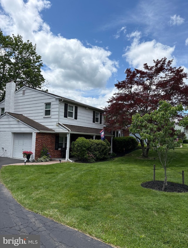 31 E Robin Rd, Southampton, PA 18966 - view of front of home featuring a front yard, a chimney, brick siding, and asphalt driveway