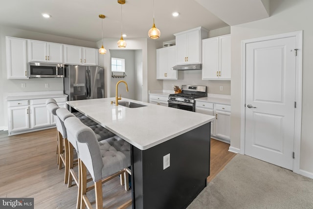 138 Merseyside Dr, Woolwich Twp, NJ 08085 - kitchen with stainless steel appliances, a sink, under cabinet range hood, an island with sink, and light countertops
