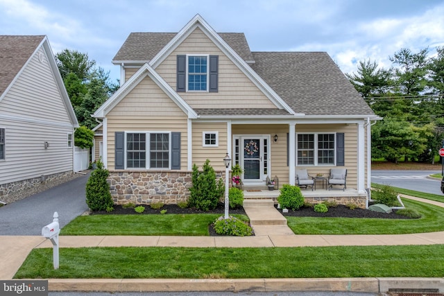 500 Prince George Dr, Lancaster, PA 17601 - view of front of home with covered porch, roof with shingles, stone siding, and a front lawn