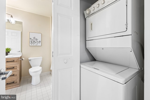 23 Pierside Dr Unit 429, Baltimore, MD 21230 - laundry area with stacked washing machine and dryer, light tile patterned flooring, and baseboards