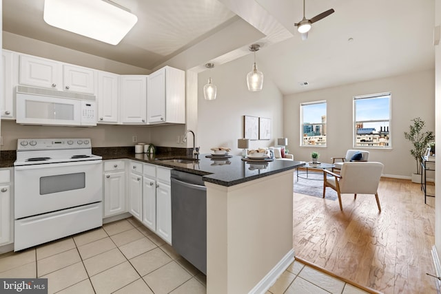 23 Pierside Dr Unit 429, Baltimore, MD 21230 - kitchen featuring white appliances, a sink, lofted ceiling, white cabinets, and a peninsula