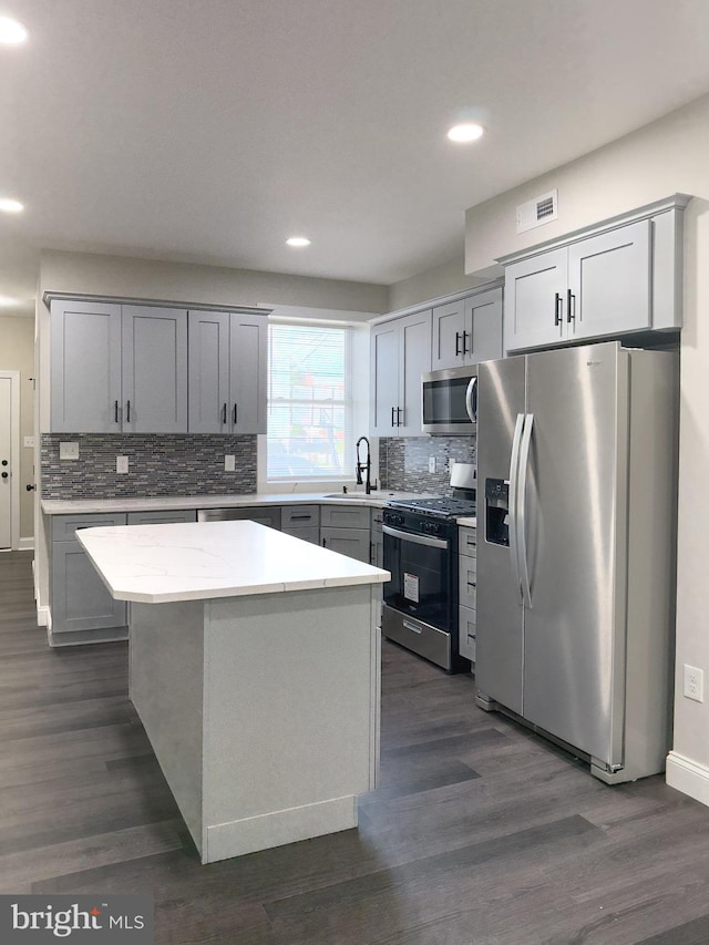 1736 E 30th St, Baltimore, MD 21218 - kitchen featuring appliances with stainless steel finishes, backsplash, a center island, recessed lighting, and dark wood finished floors
