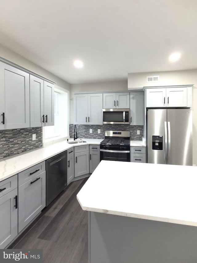 1736 E 30th St, Baltimore, MD 21218 - kitchen with stainless steel appliances, backsplash, dark wood-type flooring, gray cabinetry, and recessed lighting