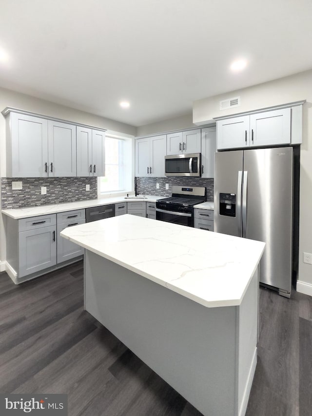 1736 E 30th St, Baltimore, MD 21218 - kitchen with stainless steel appliances, dark wood-style flooring, decorative backsplash, light stone counters, and recessed lighting