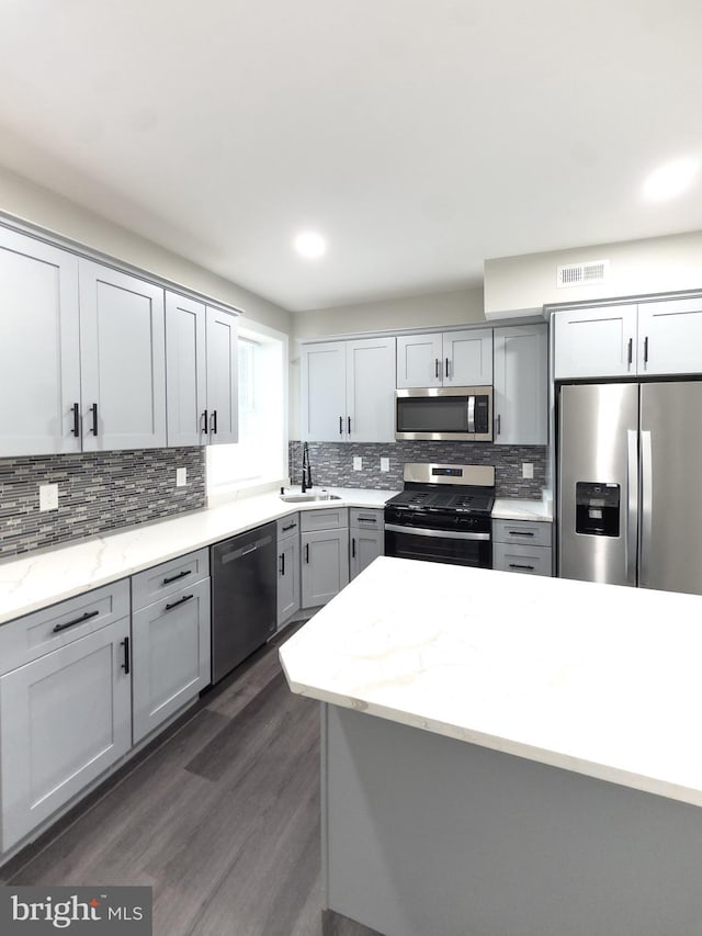 1736 E 30th St, Baltimore, MD 21218 - kitchen featuring appliances with stainless steel finishes, gray cabinets, backsplash, dark wood-style flooring, and recessed lighting
