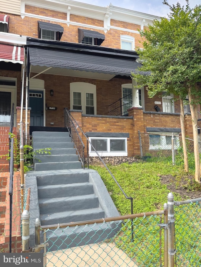 1736 E 30th St, Baltimore, MD 21218 - doorway to property with brick siding, covered porch, and a gate