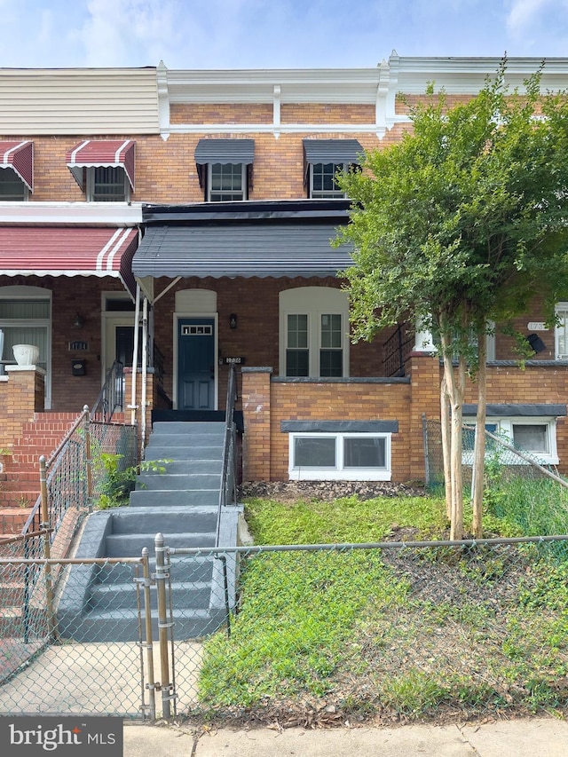 1736 E 30th St, Baltimore, MD 21218 - multi unit property with brick siding, a fenced front yard, and covered porch