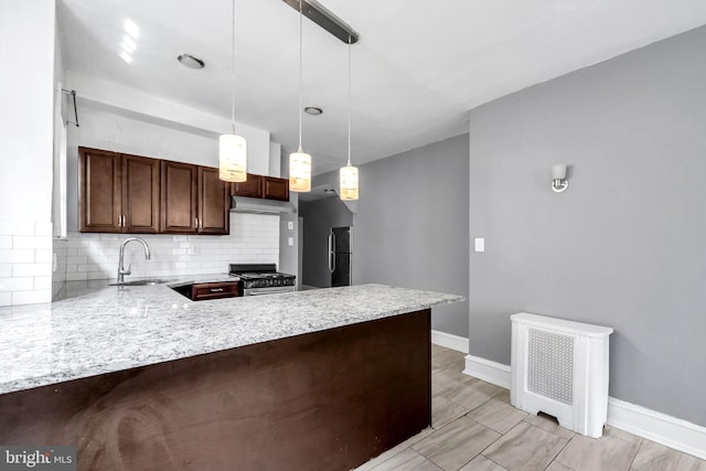 36 N Millbourne Ave, Upper Darby, PA 19082 - kitchen featuring a sink, stainless steel stove, a peninsula, backsplash, and under cabinet range hood
