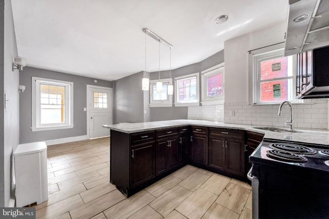 36 N Millbourne Ave, Upper Darby, PA 19082 - kitchen featuring a sink, light stone counters, a peninsula, range with electric stovetop, and backsplash