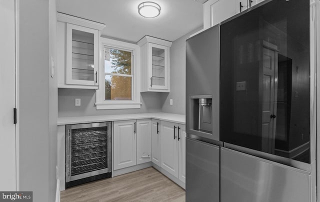 3258 N 48th St, Pennsauken, NJ 08109 - kitchen featuring beverage cooler, white cabinetry, light wood-style flooring, light countertops, and glass insert cabinets