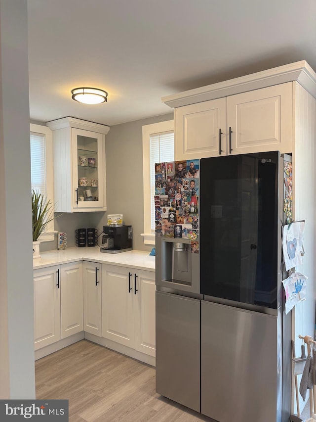3258 N 48th St, Pennsauken, NJ 08109 - kitchen featuring refrigerator with ice dispenser, light wood-type flooring, light countertops, white cabinets, and glass insert cabinets
