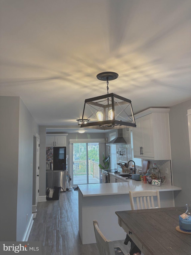 3258 N 48th St, Pennsauken, NJ 08109 - kitchen featuring a chandelier, white cabinets, a peninsula, decorative backsplash, and a sink