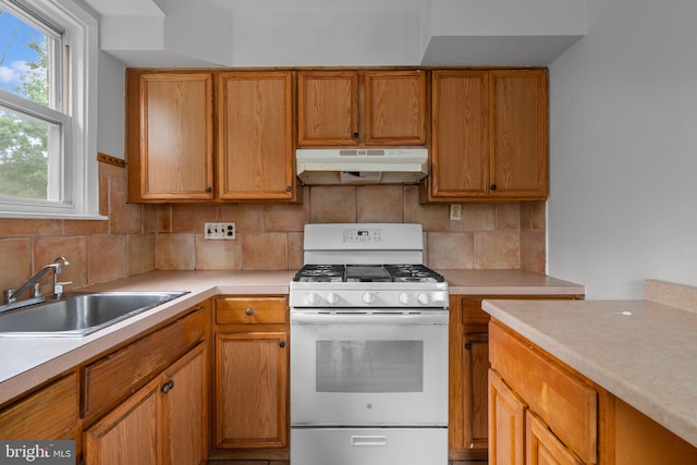 210 Erica Ter, Philadelphia, PA 19116 - kitchen featuring under cabinet range hood, white range with gas cooktop, a sink, light countertops, and backsplash