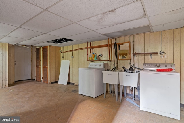 210 Erica Ter, Philadelphia, PA 19116 - basement featuring a paneled ceiling, tile patterned floors, wood walls, a sink, and washing machine and dryer