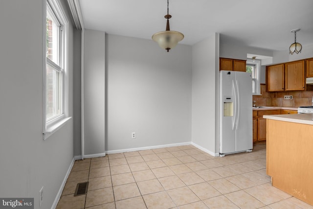 210 Erica Ter, Philadelphia, PA 19116 - kitchen with white refrigerator with ice dispenser, light countertops, decorative light fixtures, brown cabinetry, and backsplash