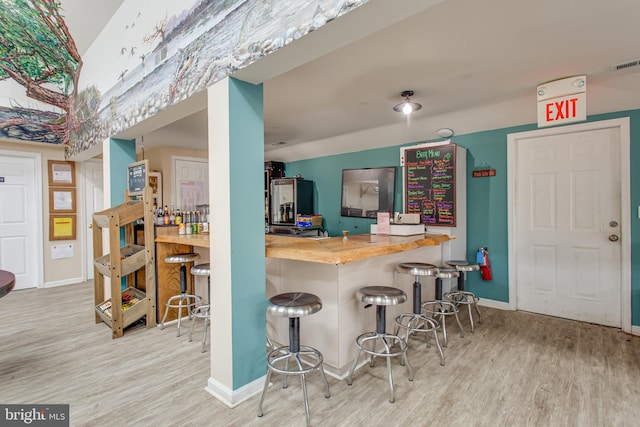 12133 Neale Sound Dr, Cobb Island, MD 20625 - kitchen with wood finished floors, a kitchen bar, and baseboards
