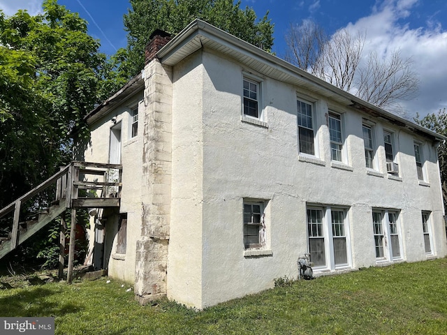 510 62nd Ave, Capitol Heights, MD 20743 - view of home's exterior with stucco siding, a lawn, a chimney, stairway, and a deck