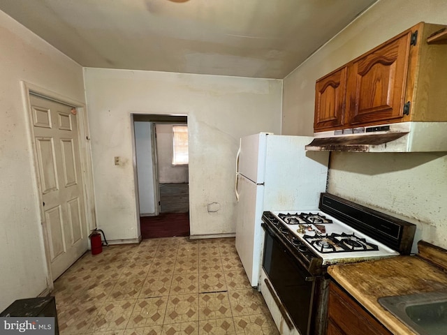 510 62nd Ave, Capitol Heights, MD 20743 - kitchen with gas range oven, under cabinet range hood, brown cabinetry, and light floors
