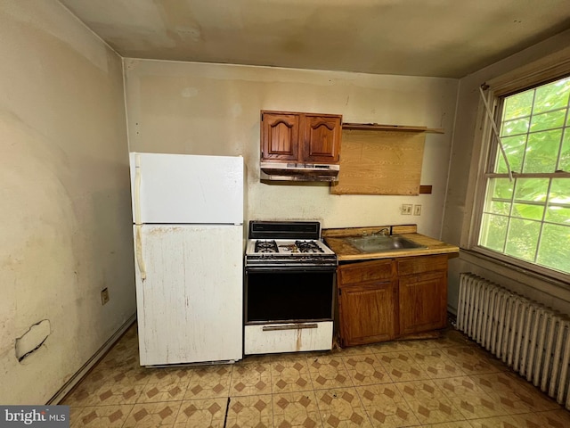 510 62nd Ave, Capitol Heights, MD 20743 - kitchen with freestanding refrigerator, range with gas stovetop, radiator heating unit, a sink, and under cabinet range hood