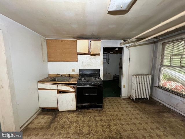510 62nd Ave, Capitol Heights, MD 20743 - kitchen with black gas range, radiator heating unit, a sink, and dark floors