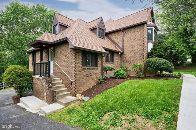7423 Round Hill Rd, Frederick, MD 21702 - tudor-style house featuring brick siding, a front lawn, and a shingled roof
