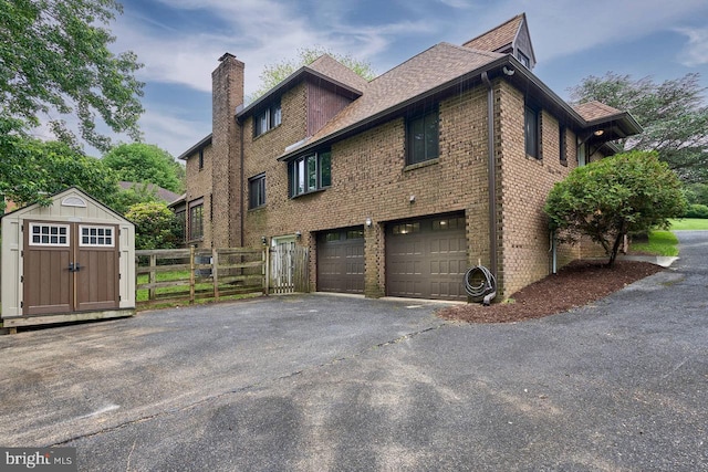 7423 Round Hill Rd, Frederick, MD 21702 - view of home's exterior with brick siding, a chimney, an attached garage, asphalt driveway, and roof with shingles