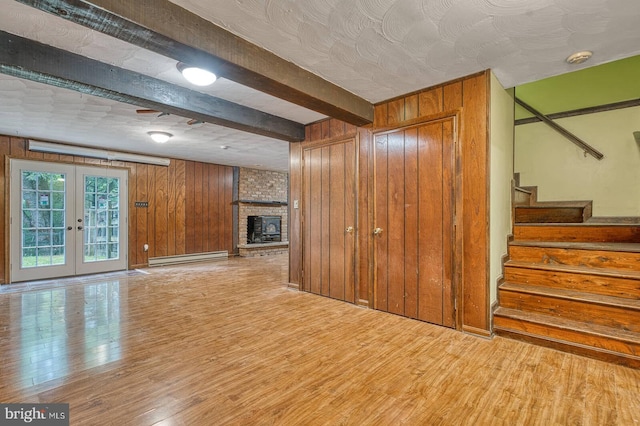 7423 Round Hill Rd, Frederick, MD 21702 - unfurnished living room with wood walls, wood finished floors, baseboard heating, stairway, and beam ceiling