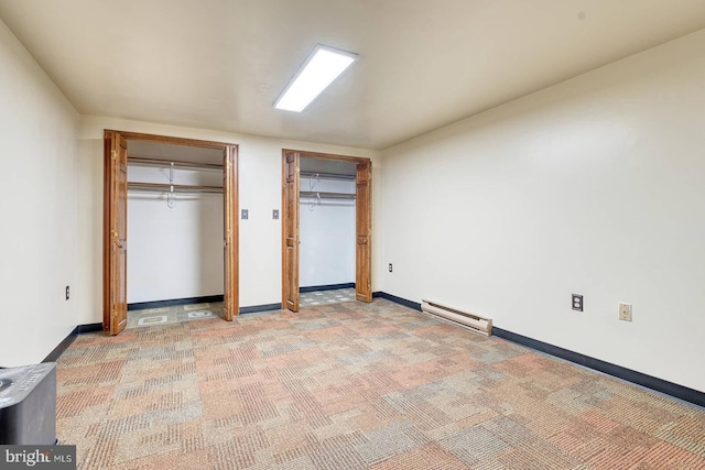 7423 Round Hill Rd, Frederick, MD 21702 - unfurnished bedroom featuring multiple closets, baseboard heating, light colored carpet, and baseboards