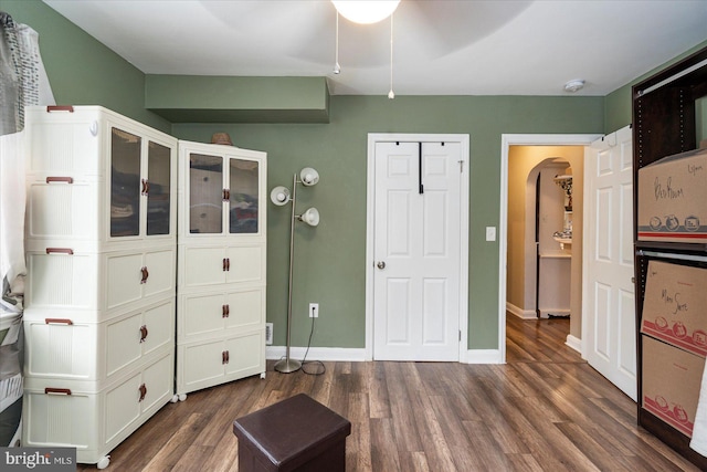 4406 Furley Ave, Baltimore, MD 21206 - bedroom with arched walkways, dark wood-style flooring, and baseboards