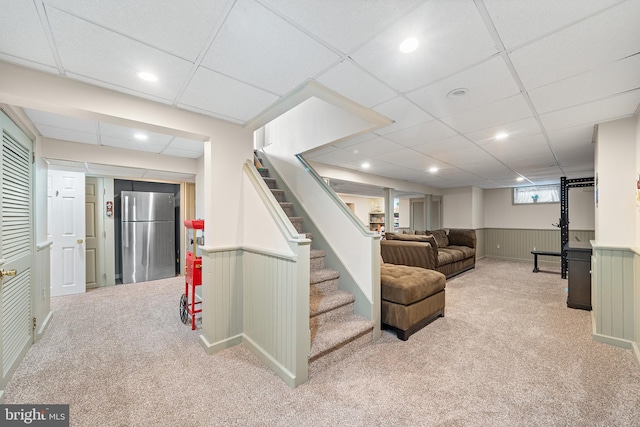 428 Hampshire Dr, Broomall, PA 19008 - below grade area with freestanding refrigerator, carpet, stairs, a wainscoted wall, and a paneled ceiling