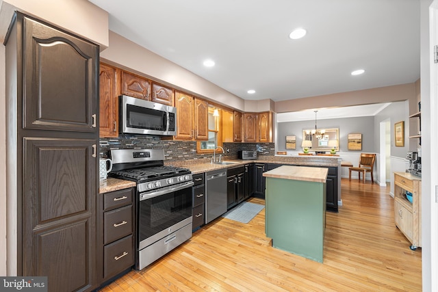 428 Hampshire Dr, Broomall, PA 19008 - kitchen featuring stainless steel appliances, a sink, light wood-style floors, a chandelier, and tasteful backsplash