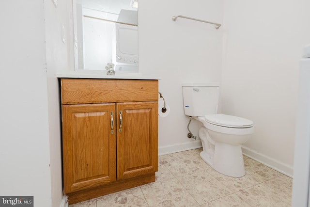 103 Stadium Cir, Inwood, WV 25428 - bathroom with baseboards, vanity, toilet, tile patterned floors, and stacked washer / dryer