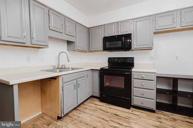 103 Stadium Cir, Inwood, WV 25428 - kitchen featuring black appliances, gray cabinetry, a sink, light wood finished floors, and light countertops