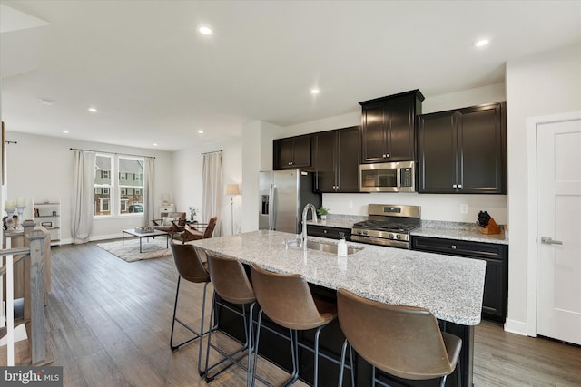 118 Fletcher Cir, Middletown, DE 19709 - kitchen with stainless steel appliances, a sink, a kitchen island with sink, a kitchen breakfast bar, and wood finished floors