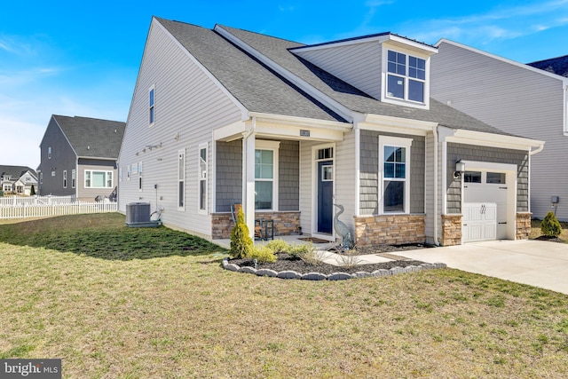 31107 Olney Way, Millsboro, DE 19966 - view of front of home featuring concrete driveway, stone siding, an attached garage, central air condition unit, and roof with shingles