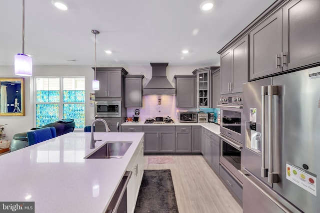 31107 Olney Way, Millsboro, DE 19966 - kitchen with appliances with stainless steel finishes, a sink, gray cabinetry, premium range hood, and light wood-style flooring