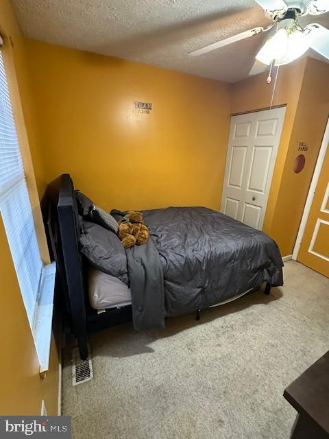 6708 Pauline Ct, Bryans Road, MD 20616 - carpeted bedroom featuring a textured ceiling, a ceiling fan, and multiple windows