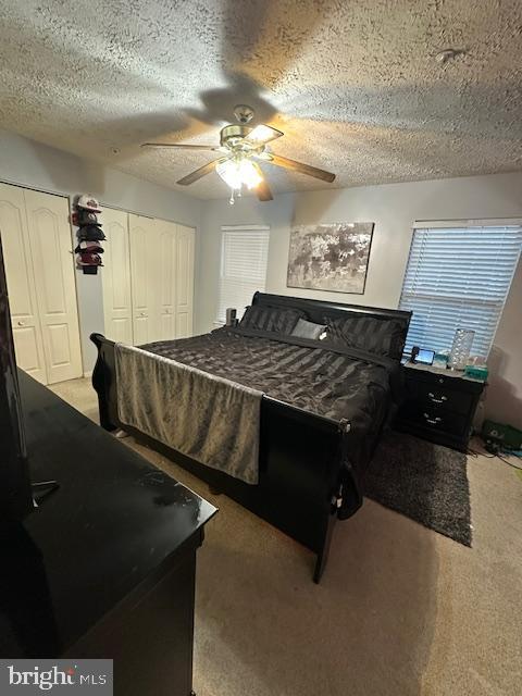 6708 Pauline Ct, Bryans Road, MD 20616 - bedroom with carpet flooring, a textured ceiling, a ceiling fan, and two closets