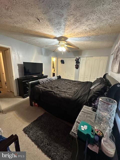 6708 Pauline Ct, Bryans Road, MD 20616 - carpeted bedroom with a textured ceiling, ceiling fan, and two closets
