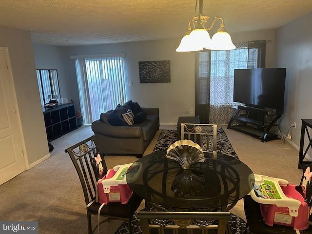 6708 Pauline Ct, Bryans Road, MD 20616 - living room with carpet flooring, baseboards, a chandelier, and a textured ceiling