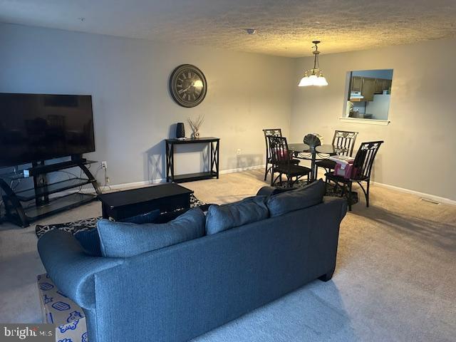 6708 Pauline Ct, Bryans Road, MD 20616 - carpeted living room featuring baseboards, a textured ceiling, and a chandelier