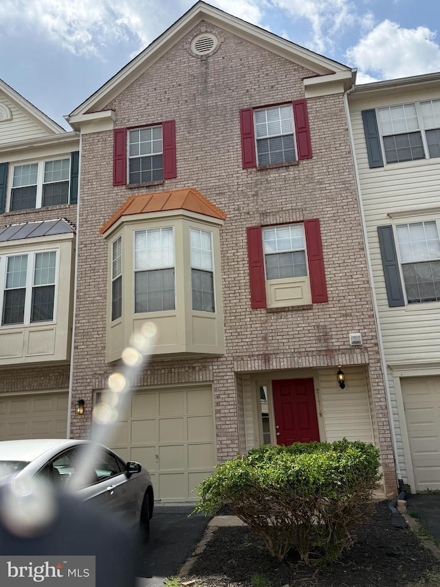 21748 Kings Crossing Ter, Ashburn, VA 20147 - townhome / multi-family property with brick siding, an attached garage, and driveway
