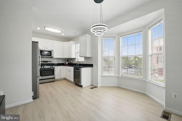 21748 Kings Crossing Ter, Ashburn, VA 20147 - kitchen with stainless steel appliances, light wood-type flooring, baseboards, a sink, and recessed lighting